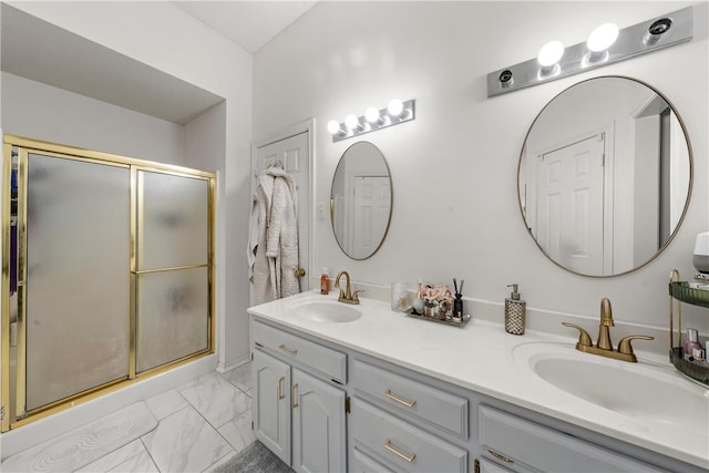 full bathroom with marble finish floor, a sink, a shower stall, and double vanity