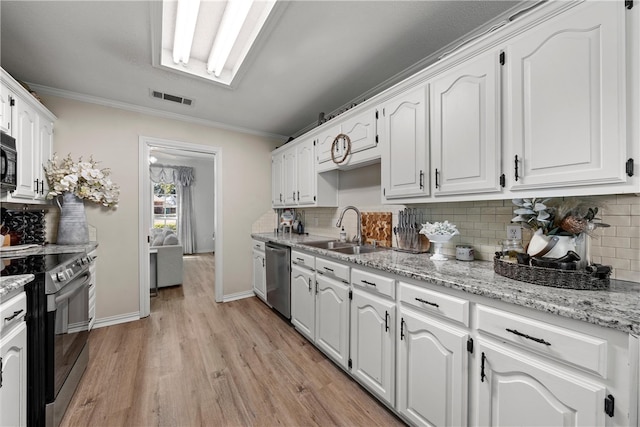 kitchen featuring crown molding, visible vents, appliances with stainless steel finishes, white cabinets, and a sink