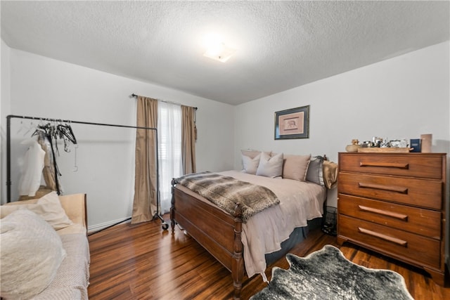 bedroom featuring dark wood finished floors and a textured ceiling