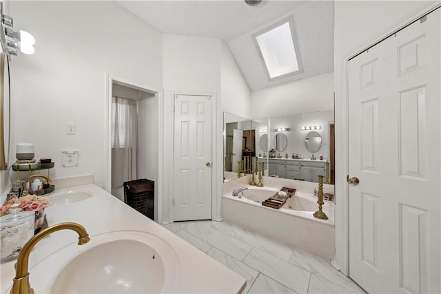 bathroom featuring double vanity, vaulted ceiling with skylight, and a sink