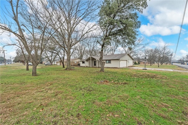 view of yard featuring an attached garage and driveway