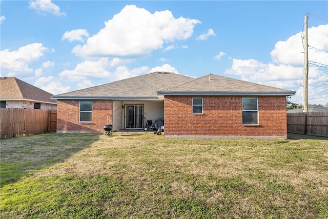 rear view of property featuring a lawn