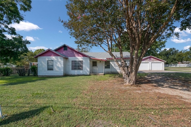 view of front facade featuring an outbuilding, a front yard, and a garage