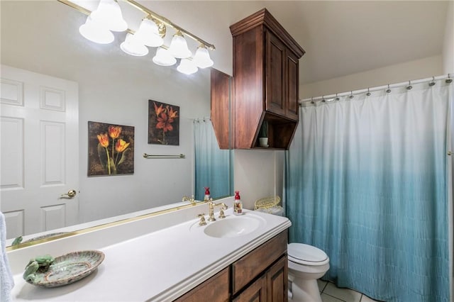 bathroom with toilet, vanity, and tile patterned floors