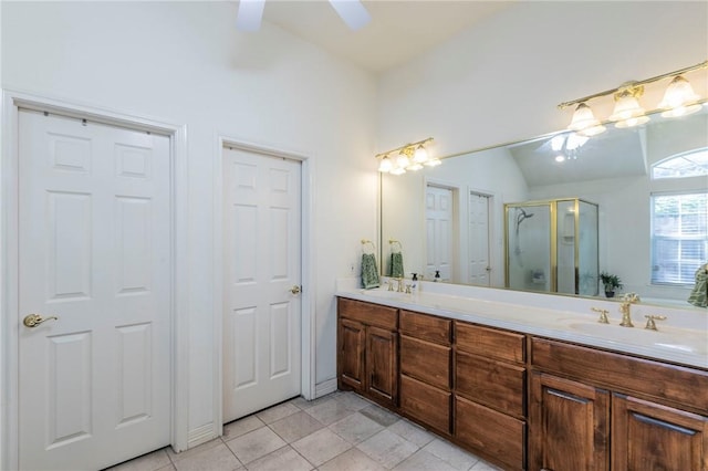 bathroom with ceiling fan, tile patterned floors, lofted ceiling, a shower with door, and vanity