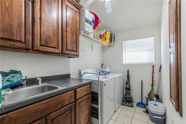 clothes washing area featuring cabinets, light tile patterned flooring, washer and clothes dryer, and sink