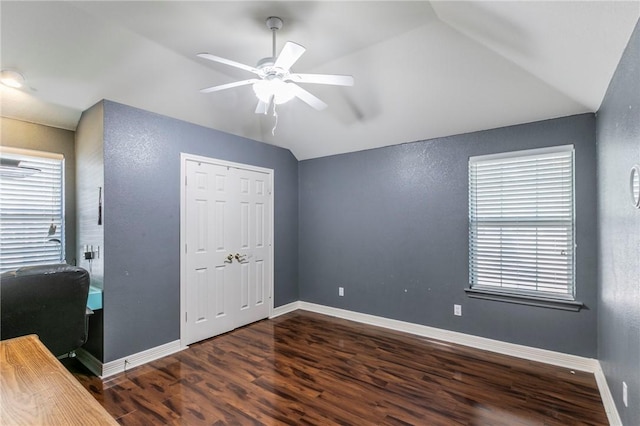 unfurnished bedroom with dark hardwood / wood-style floors, ceiling fan, lofted ceiling, and multiple windows