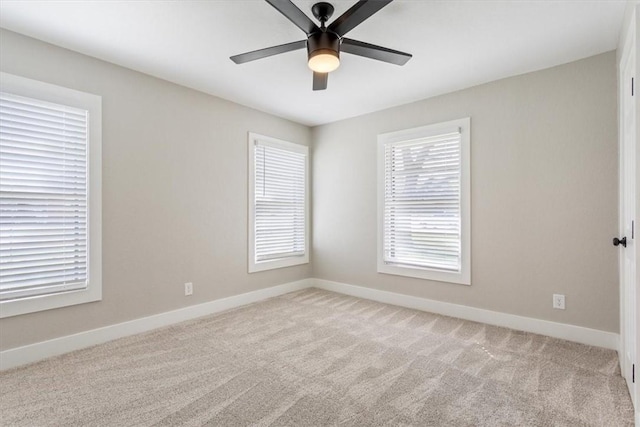 unfurnished room with light colored carpet and ceiling fan