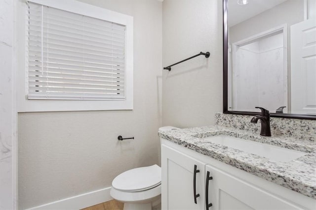 bathroom with wood-type flooring, vanity, and toilet