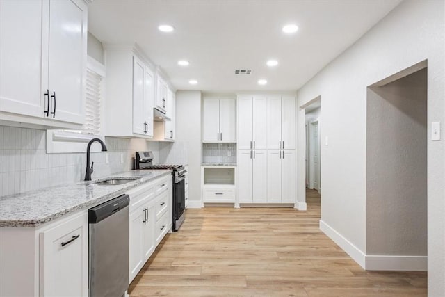 kitchen featuring white cabinets, sink, stainless steel appliances, and light hardwood / wood-style flooring