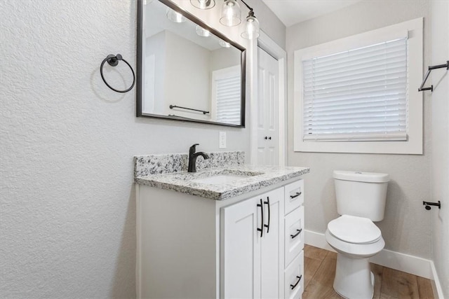 bathroom with hardwood / wood-style floors, vanity, and toilet