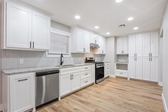 kitchen featuring white cabinetry, sink, appliances with stainless steel finishes, and light hardwood / wood-style flooring