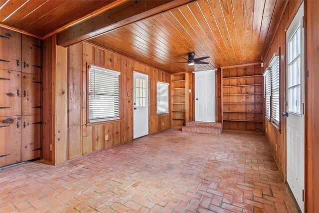 spare room featuring ceiling fan, wood ceiling, and wooden walls