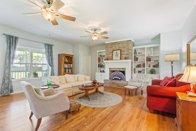 living room with ceiling fan, light hardwood / wood-style floors, and a brick fireplace