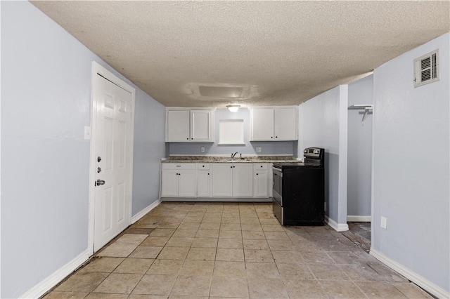 kitchen with black electric range oven, a textured ceiling, sink, white cabinetry, and light tile patterned flooring