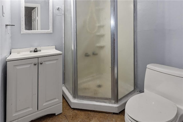 bathroom featuring vanity, toilet, and a shower with door