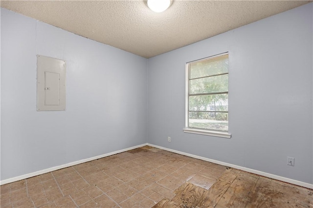 unfurnished room featuring electric panel and a textured ceiling