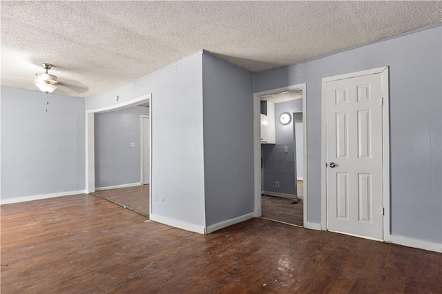 empty room featuring a textured ceiling, ceiling fan, and dark hardwood / wood-style floors