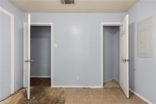 unfurnished bedroom featuring electric panel, a closet, and a textured ceiling