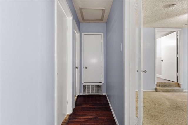 hall featuring dark hardwood / wood-style flooring and a textured ceiling