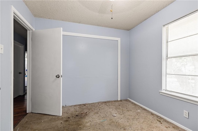 unfurnished room with a textured ceiling