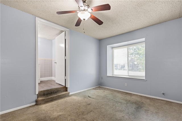 carpeted spare room featuring a textured ceiling and ceiling fan