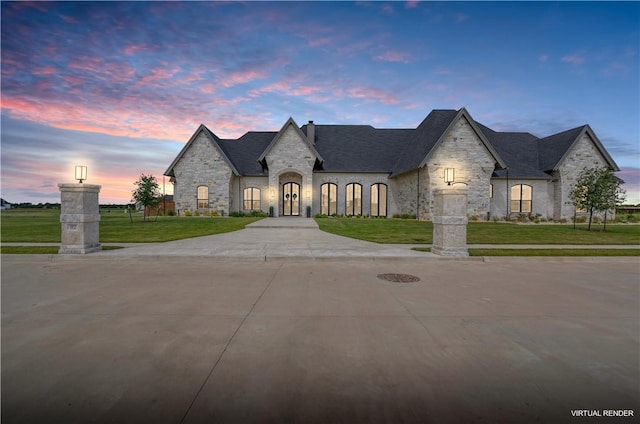 french provincial home with a lawn