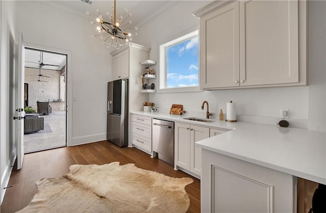 kitchen featuring sink, white cabinetry, crown molding, appliances with stainless steel finishes, and hardwood / wood-style floors