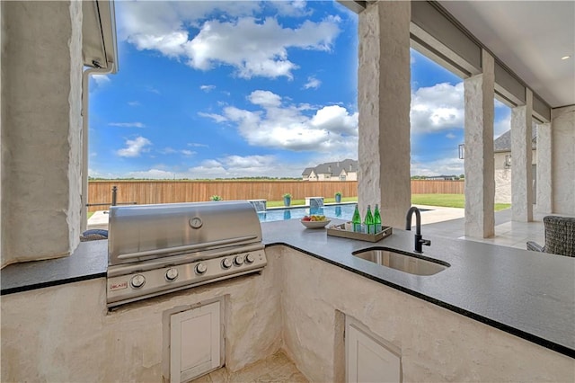 view of patio featuring area for grilling, sink, a swimming pool, and grilling area