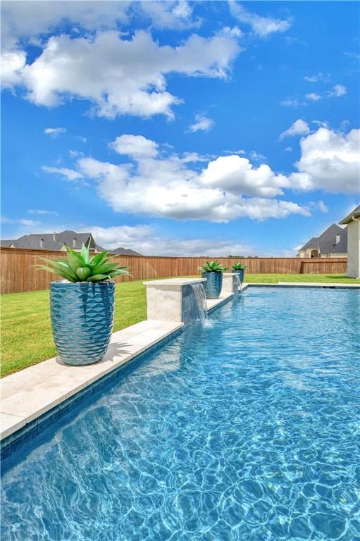 view of pool featuring pool water feature and a yard