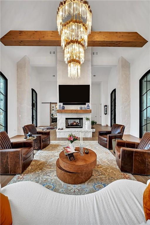 living room featuring beamed ceiling and a notable chandelier