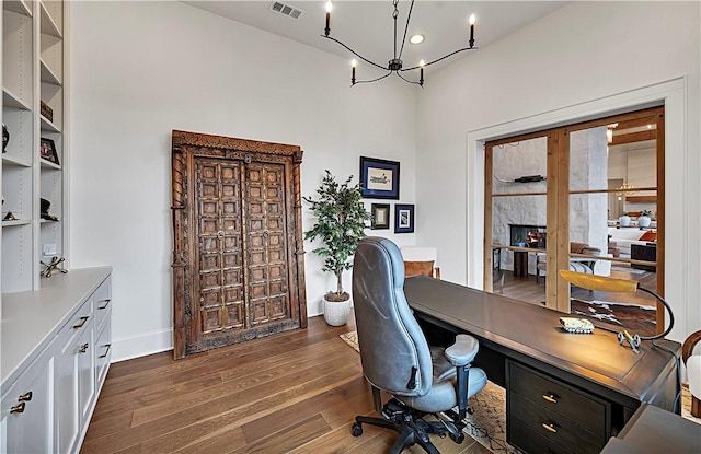 home office featuring a notable chandelier and dark hardwood / wood-style floors