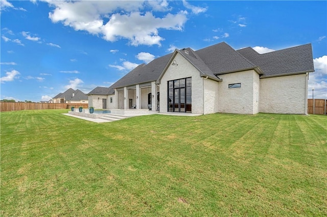 back of property featuring a pool, a yard, and a patio