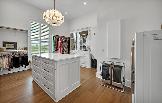 walk in closet with an inviting chandelier and light hardwood / wood-style flooring