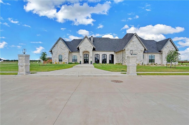 french country inspired facade featuring a front lawn