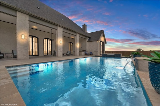 pool at dusk featuring a patio