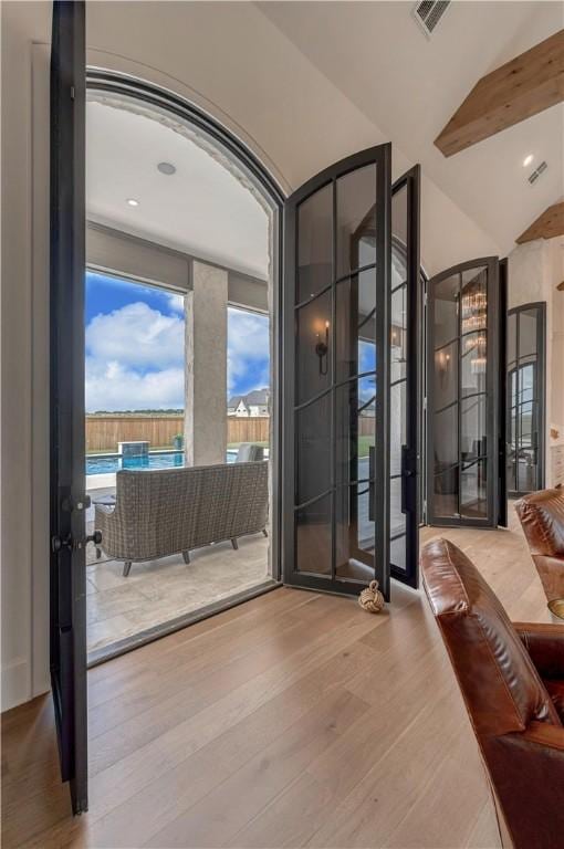 doorway with vaulted ceiling and hardwood / wood-style floors