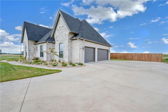 view of side of property featuring a garage and a lawn