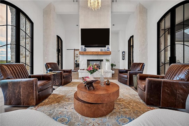 living room with a healthy amount of sunlight, a towering ceiling, and an inviting chandelier