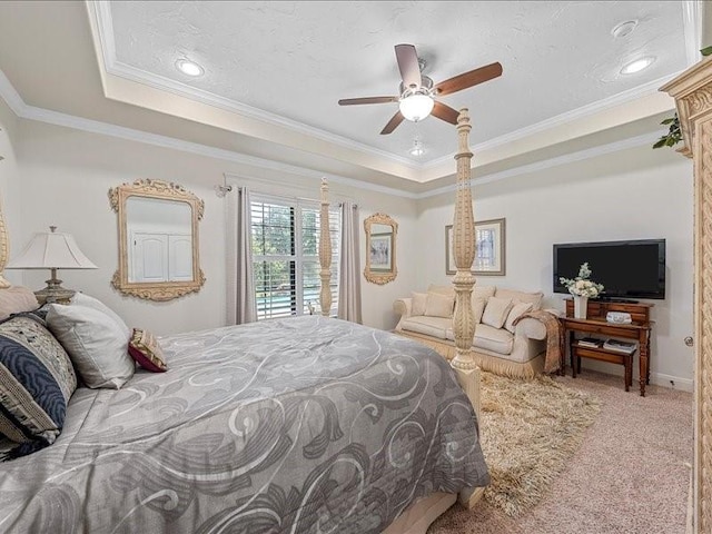 carpeted bedroom featuring a tray ceiling, ceiling fan, and ornamental molding