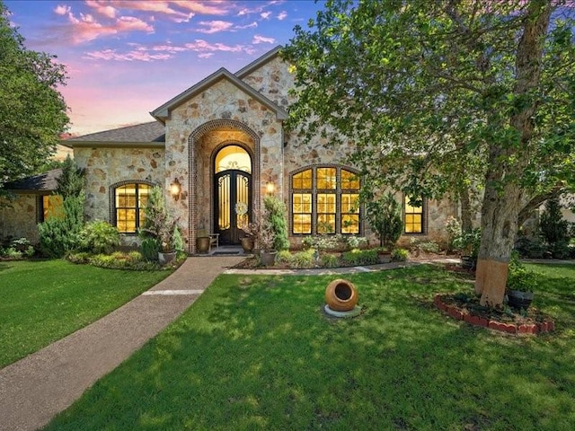 view of front of house featuring a yard and french doors