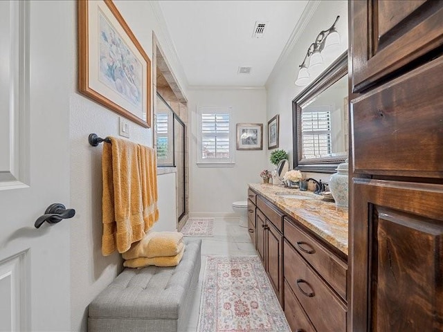 bathroom featuring vanity, toilet, a shower with door, and ornamental molding