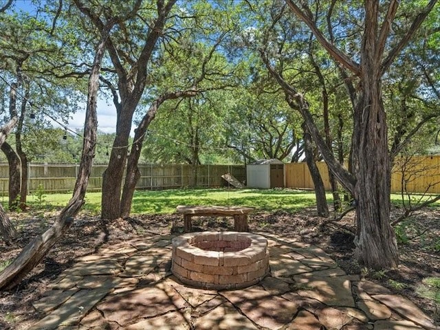 view of patio / terrace featuring a fire pit and a storage shed