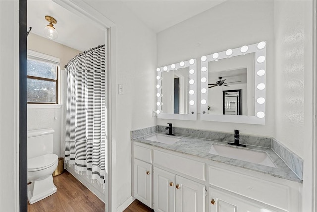 full bathroom with shower / bath combo, vanity, ceiling fan, hardwood / wood-style floors, and toilet