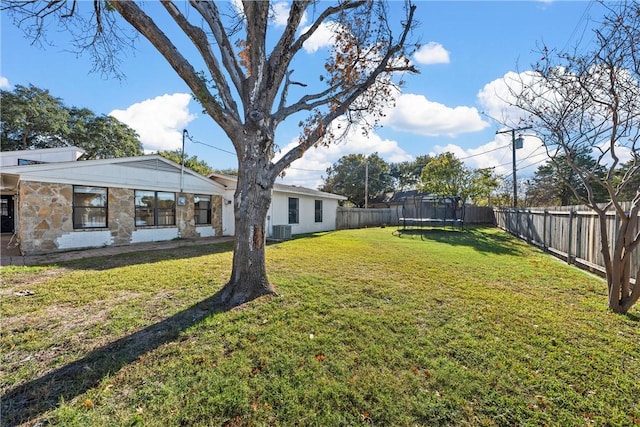 view of yard featuring a trampoline and central AC unit