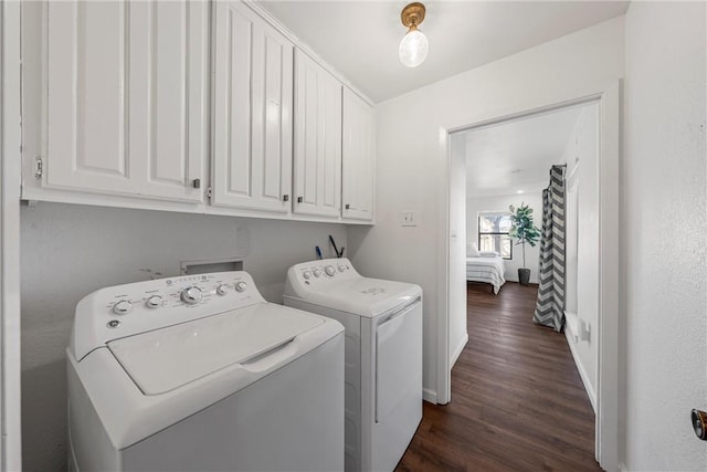 laundry room with cabinets, independent washer and dryer, and dark hardwood / wood-style floors