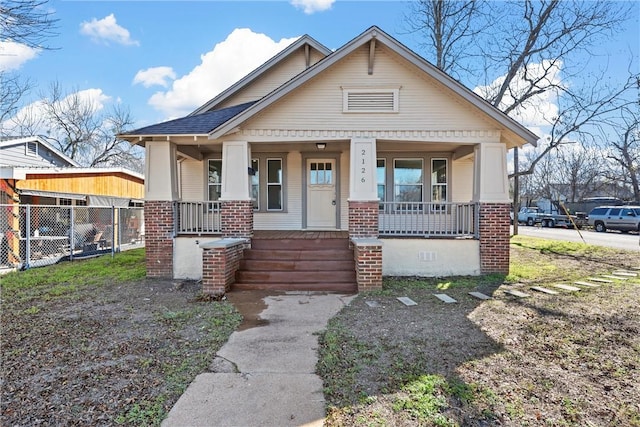 bungalow with crawl space, covered porch, fence, and brick siding