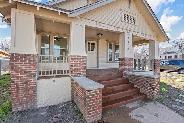 property entrance featuring covered porch and brick siding