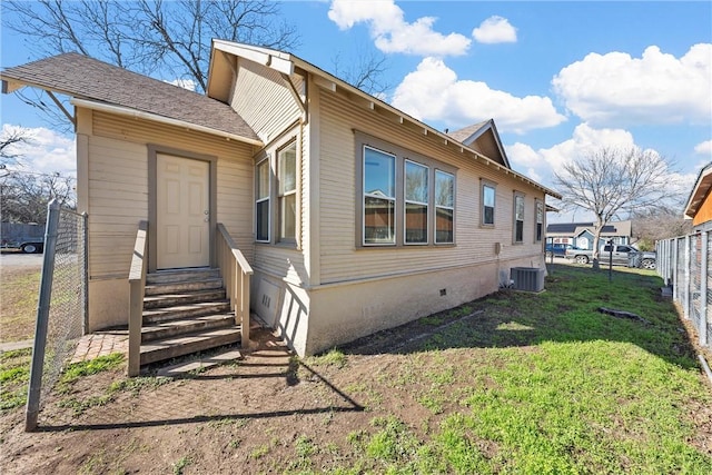 view of side of property with a lawn and central AC unit