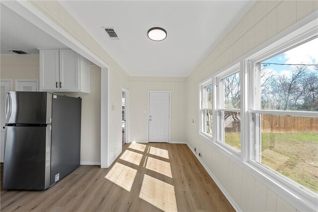 kitchen featuring light stone counters, white dishwasher, sink, white cabinetry, and stainless steel refrigerator